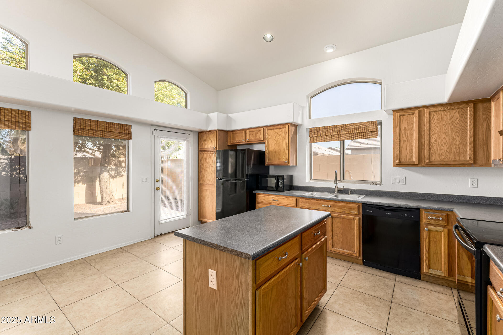 10628 West Coronado Road Avondale, AZ 85392 - Photo 7 of 29 a kitchen with a stove a sink a refrigerator and a window