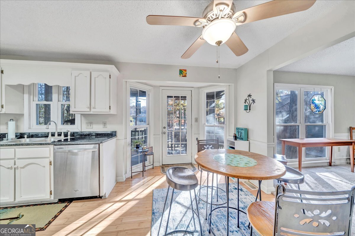 637 Will Scarlet Way Macon, GA 31220 - Photo 14 of 38 a kitchen with stainless steel appliances granite countertop a stove top oven a refrigerator a dining table and chairs with wooden floor