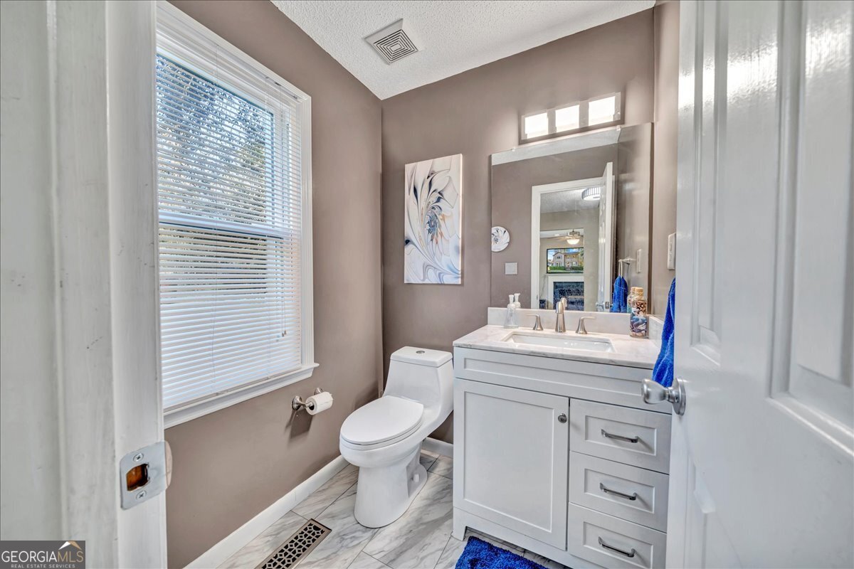 637 Will Scarlet Way Macon, GA 31220 - Photo 8 of 38 a bathroom with a granite countertop toilet sink and mirror