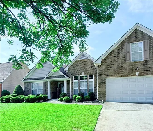 a front view of a house with a garden and trees