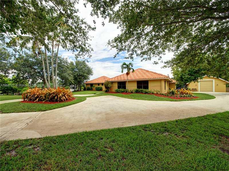 17641 Southwest 70th Place Southwest Ranches, FL 33331 - Photo 14 of 24 a front view of a house with a yard and garage