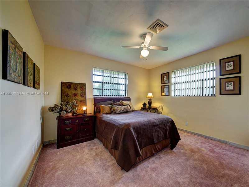 17641 Southwest 70th Place Southwest Ranches, FL 33331 - Photo 20 of 24 a bedroom with a bed and windows