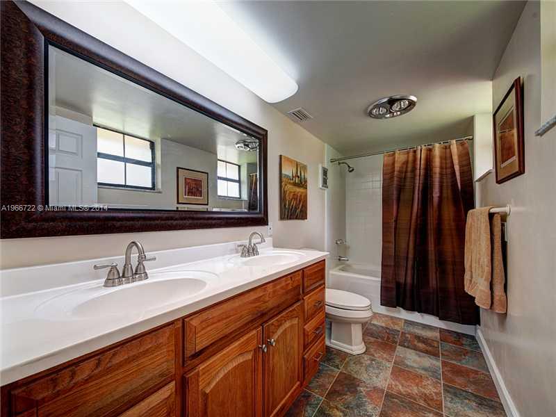 17641 Southwest 70th Place Southwest Ranches, FL 33331 - Photo 10 of 24 a bathroom with a sink a toilet a mirror and shower
