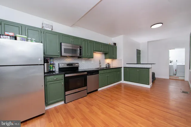 a kitchen with granite countertop a refrigerator and a stove top oven