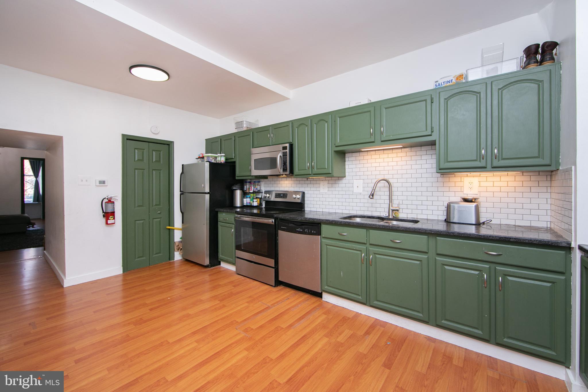 876 North 19th Street Philadelphia, PA 19130 - Photo 12 of 49 a kitchen with granite countertop wooden cabinets a refrigerator and a sink