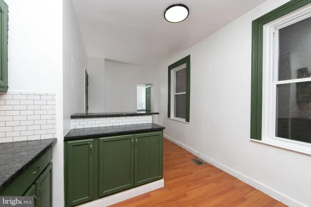 a kitchen with a sink and a stove with wooden floor