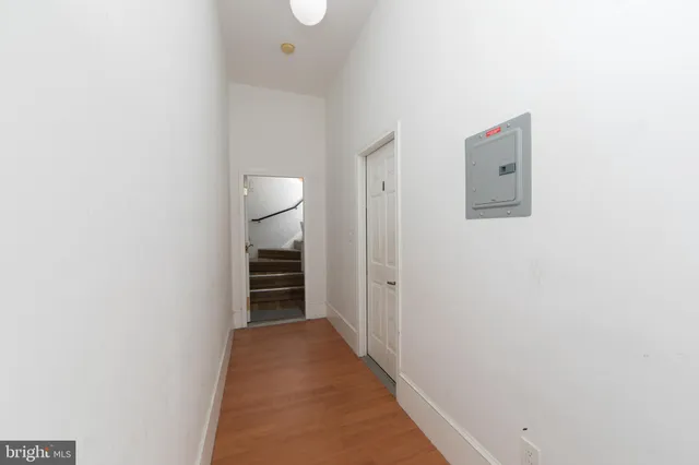 a walk in closet with wooden floor