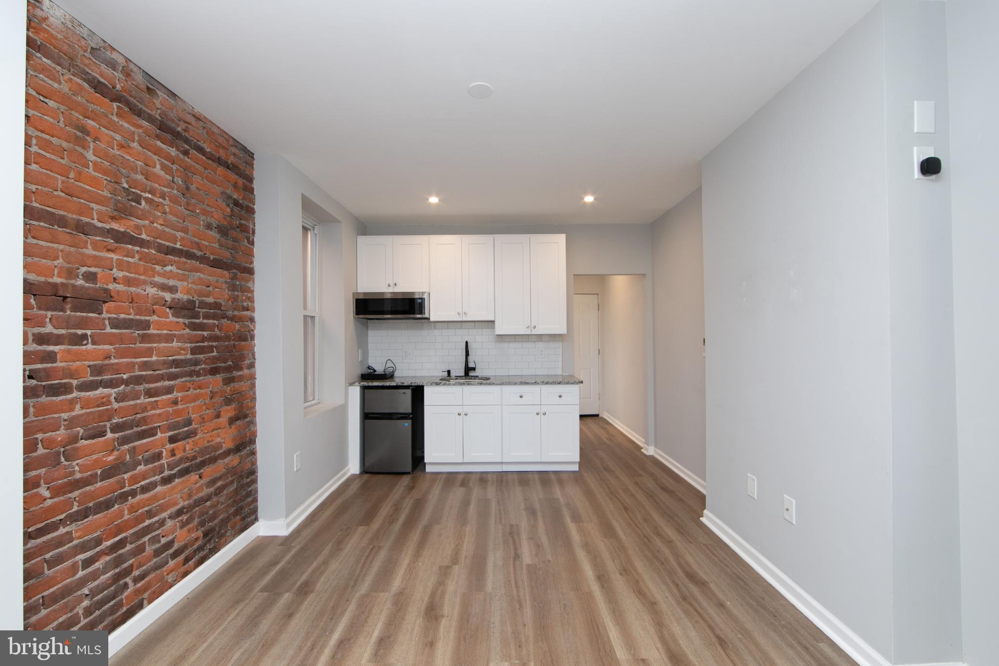 876 North 19th Street Philadelphia, PA 19130 - Photo 25 of 49 a kitchen with cabinets wooden floor and stainless steel appliances