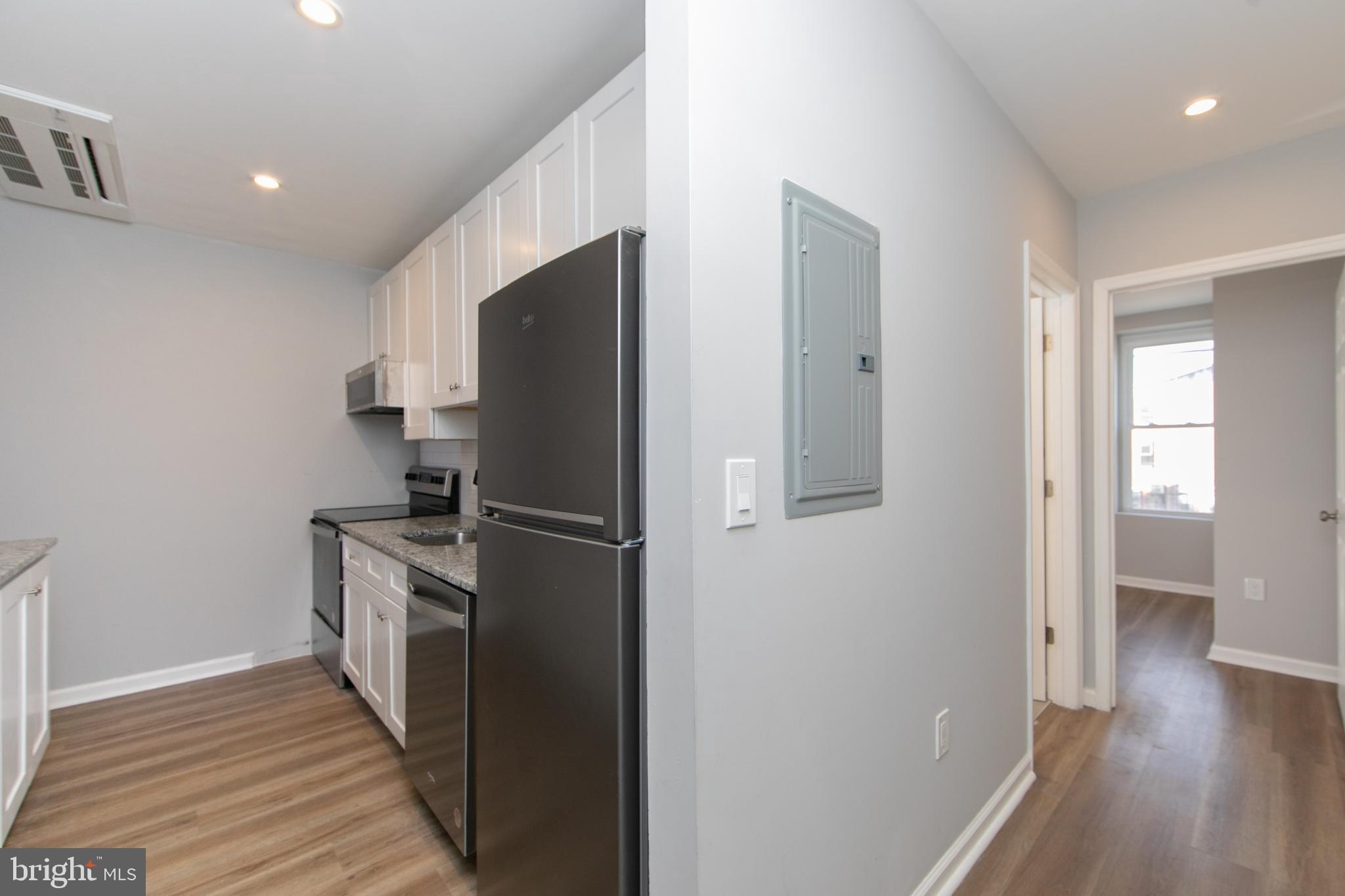 876 North 19th Street Philadelphia, PA 19130 - Photo 28 of 49 a kitchen with a refrigerator a sink and wooden floor