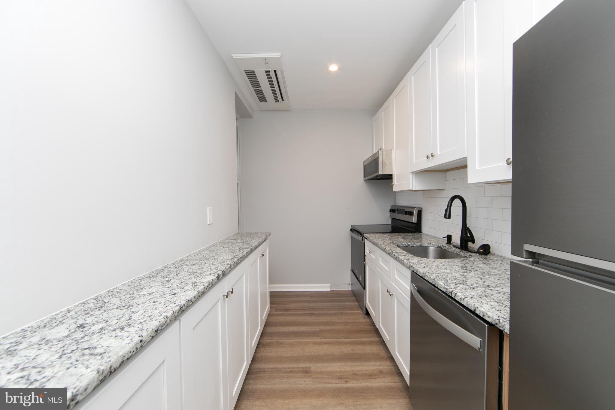 876 North 19th Street Philadelphia, PA 19130 - Photo 29 of 49 a kitchen with granite countertop a sink and cabinets
