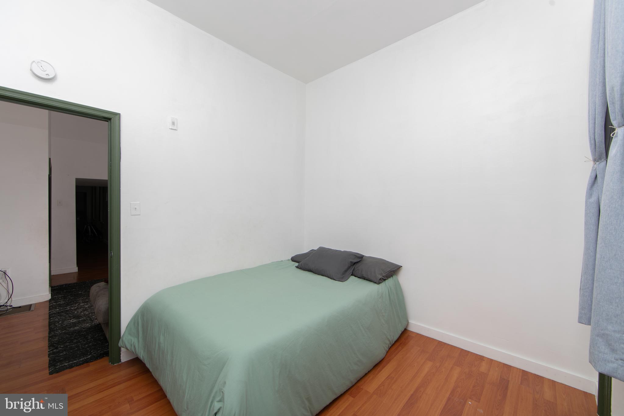 876 North 19th Street Philadelphia, PA 19130 - Photo 3 of 49 a bedroom with a bed and wooden floor