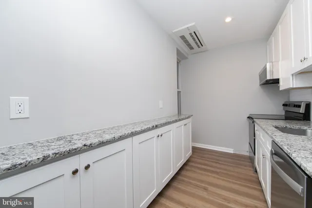 a kitchen with granite countertop a sink and a stove