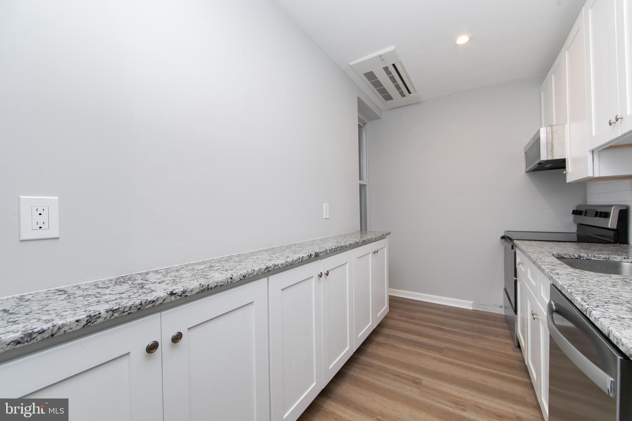 876 North 19th Street Philadelphia, PA 19130 - Photo 31 of 49 a kitchen with granite countertop a sink and a stove