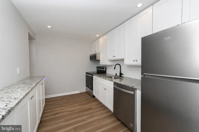 a kitchen with a sink a stove top oven and cabinets