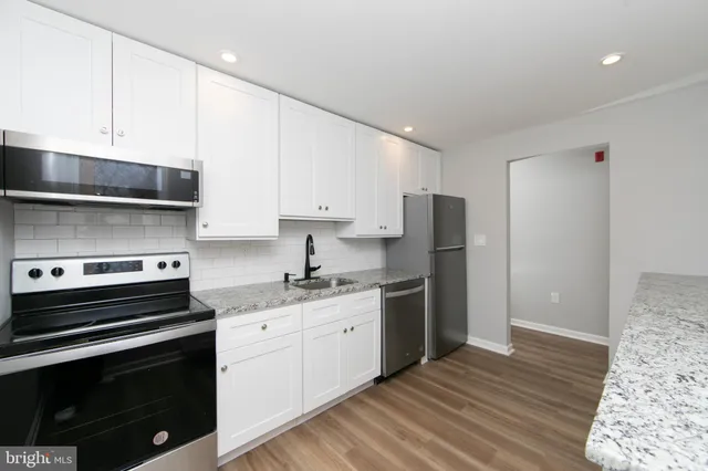 a kitchen with stainless steel appliances a stove a sink and a refrigerator