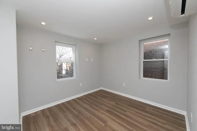 an empty room with windows and closet