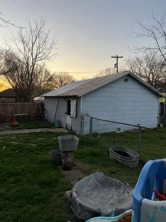 a view of backyard of house with outdoor seating and barbeque oven