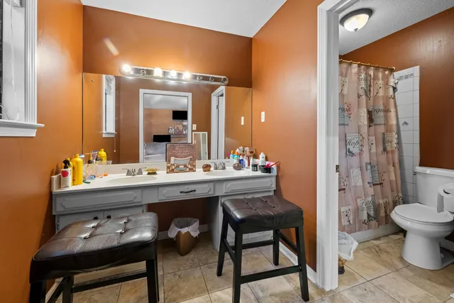 a bathroom with a sink a toilet and a mirror