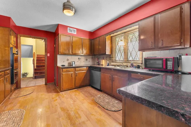 a kitchen with stainless steel appliances granite countertop a stove a sink and a microwave