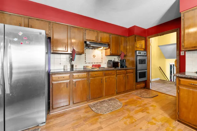 a kitchen with stainless steel appliances granite countertop a refrigerator and a sink
