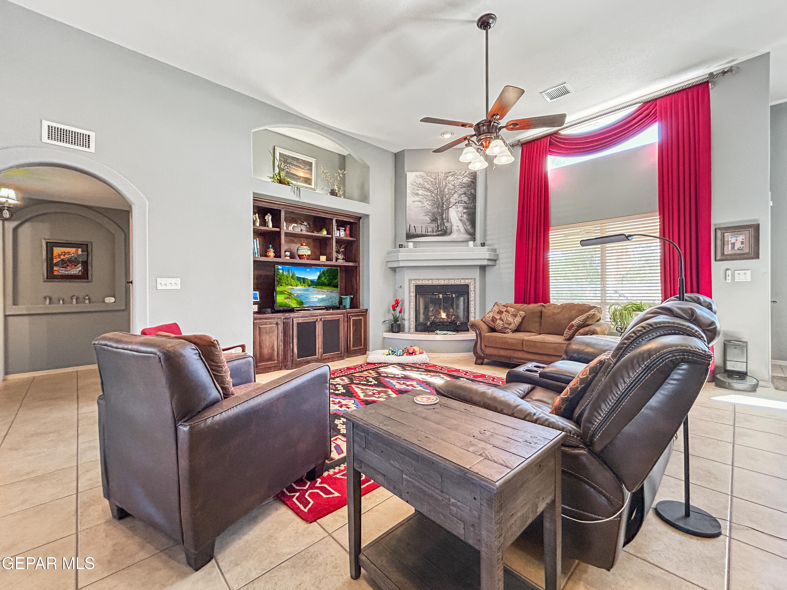 6680 Capitan Ridge El Paso, TX 79912 - Photo 2 of 47 a living room with furniture a fireplace and a chandelier