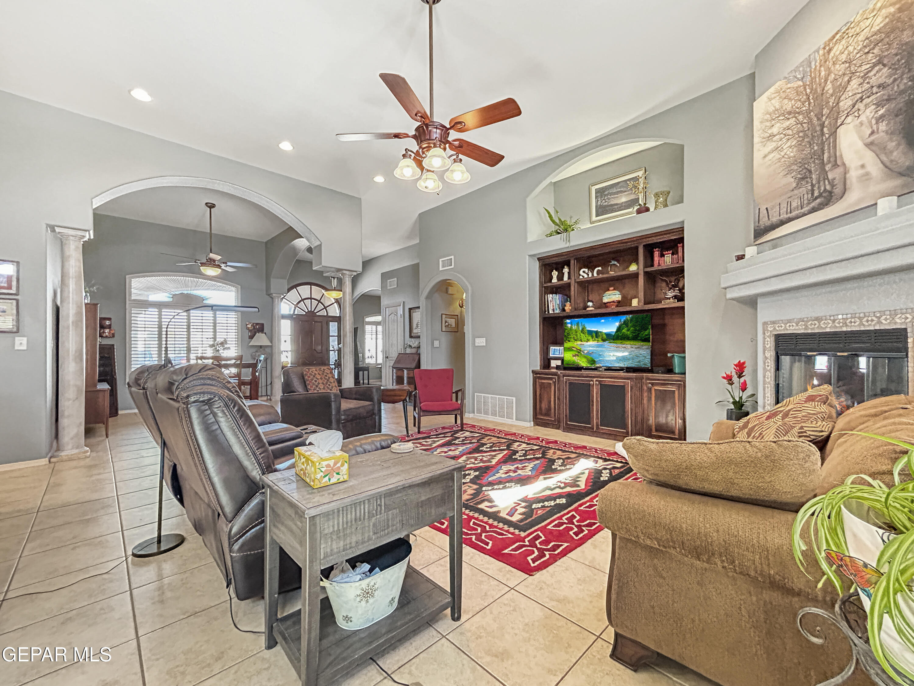 6680 Capitan Ridge El Paso, TX 79912 - Photo 21 of 47 a living room with furniture a chandelier and a flat screen tv