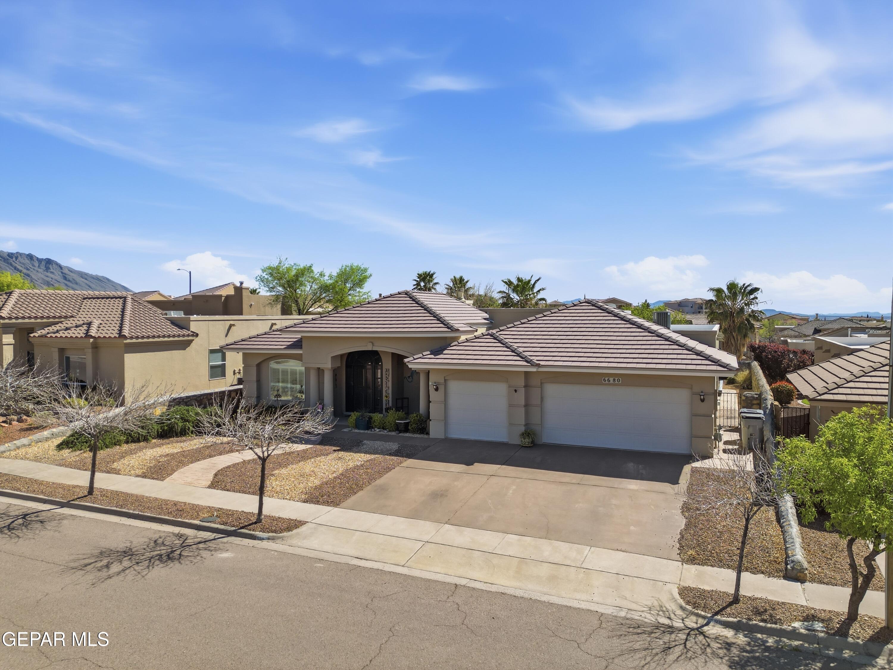 6680 Capitan Ridge El Paso, TX 79912 - Photo 10 of 47 a front view of a house with a garden and mountain view