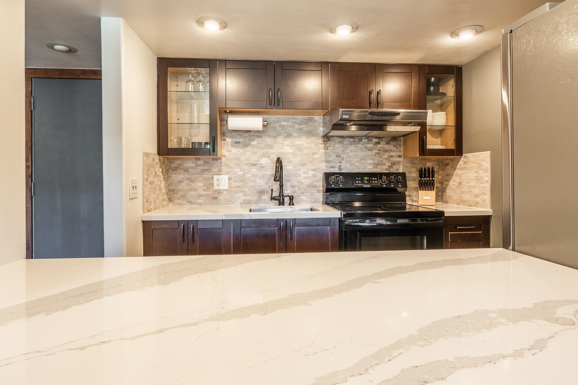 2289 Sierra Nevada Road, Unit F11 Mammoth Lakes, CA 93546 - Photo 5 of 17 a kitchen with kitchen island granite countertop a stove and a refrigerator