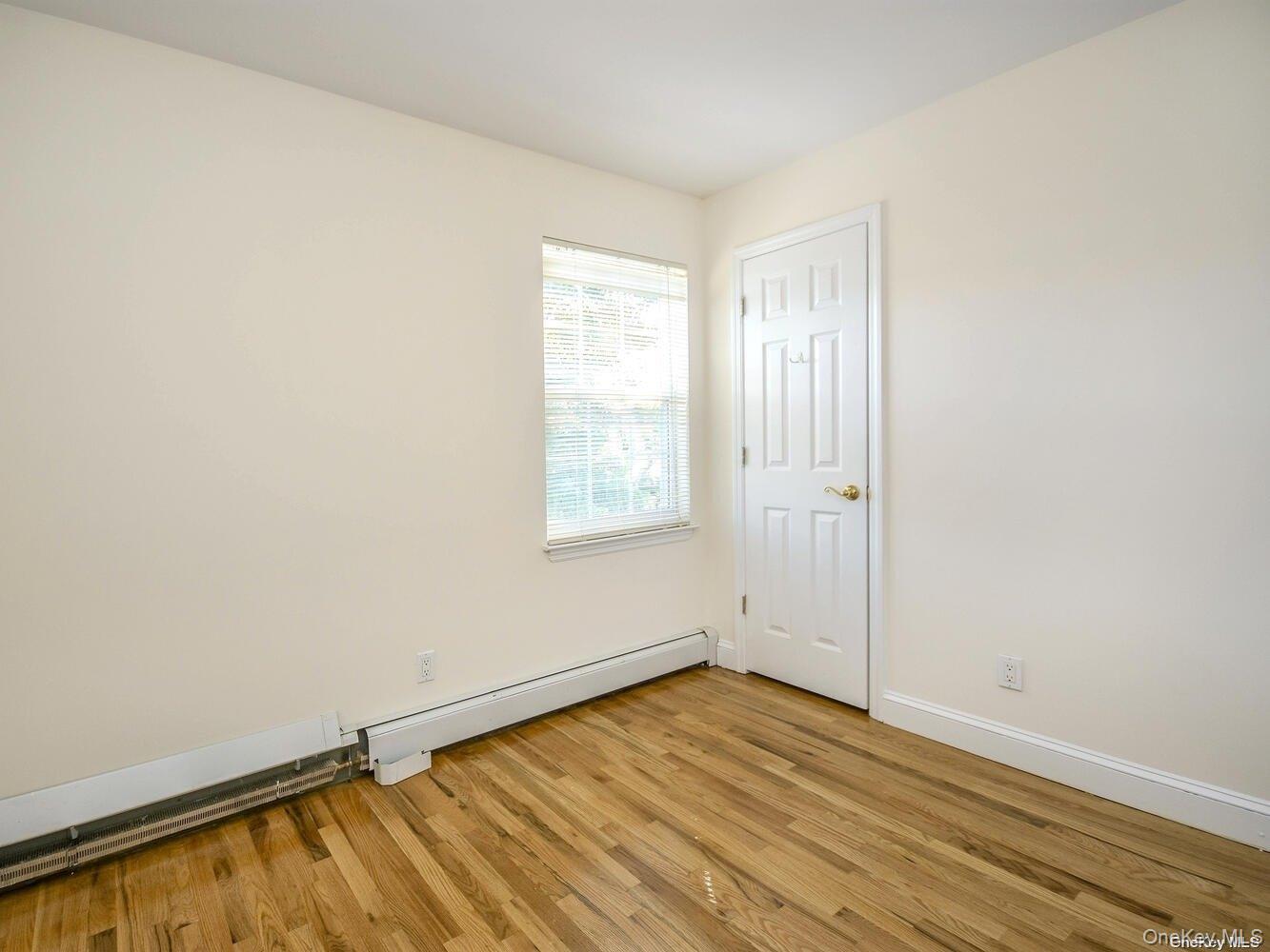34 Firwood Road, Unit B Port Washington, NY 11050 - Photo 12 of 25 an empty room with wooden floor and windows