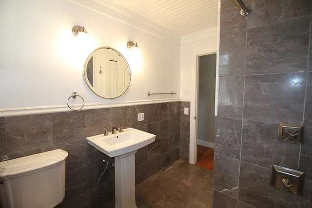 a bathroom with a sink toilet and a mirror