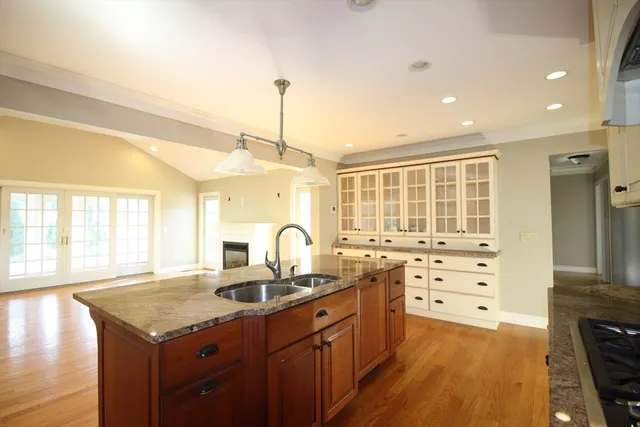a kitchen with granite countertop a sink a counter space appliances and cabinets