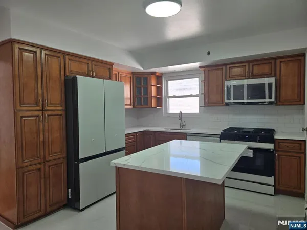 a kitchen with stainless steel appliances granite countertop a refrigerator and a microwave
