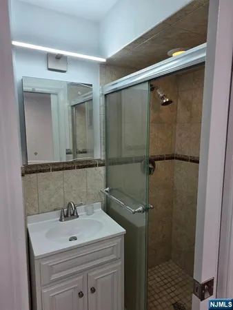 a bathroom with a sink mirror and shower