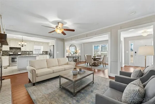 a living room with furniture ceiling fan and a rug
