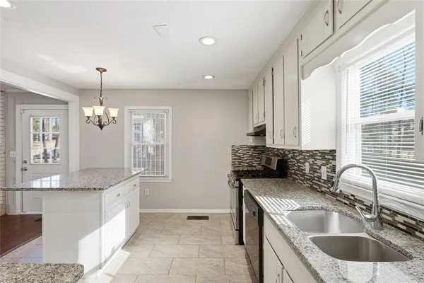 a kitchen with granite countertop a sink and a stove
