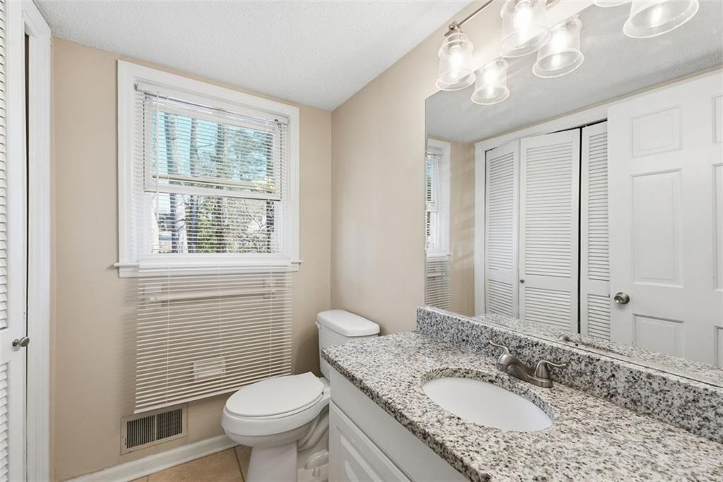 2328 Horseshoe Bend Road Southwest Marietta, GA 30064 - Photo 17 of 44 a bathroom with a granite countertop toilet a sink and a mirror