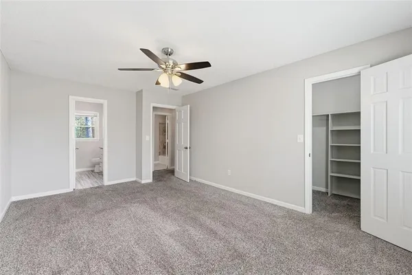 a view of a big room with closet and a ceiling fan