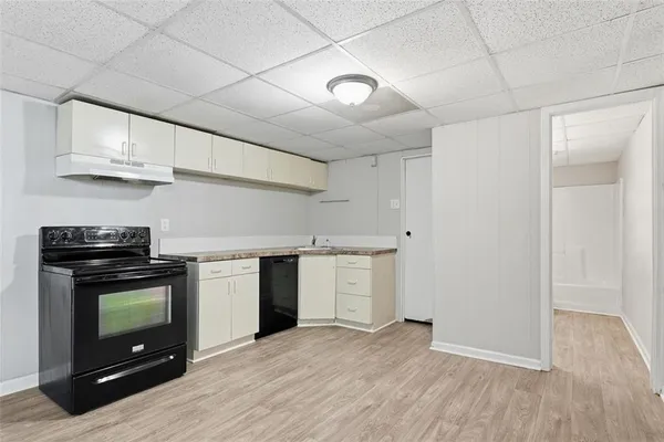 a kitchen with granite countertop a stove a microwave and wooden floors
