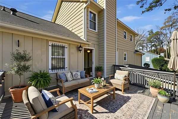 a view of a patio with couches chairs and wooden floor