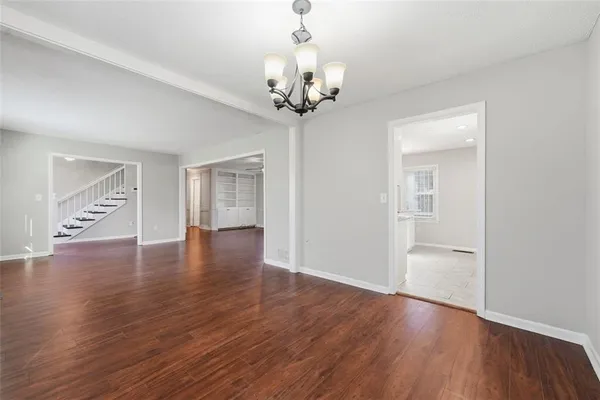 a view of a livingroom with wooden floor and a chandelier