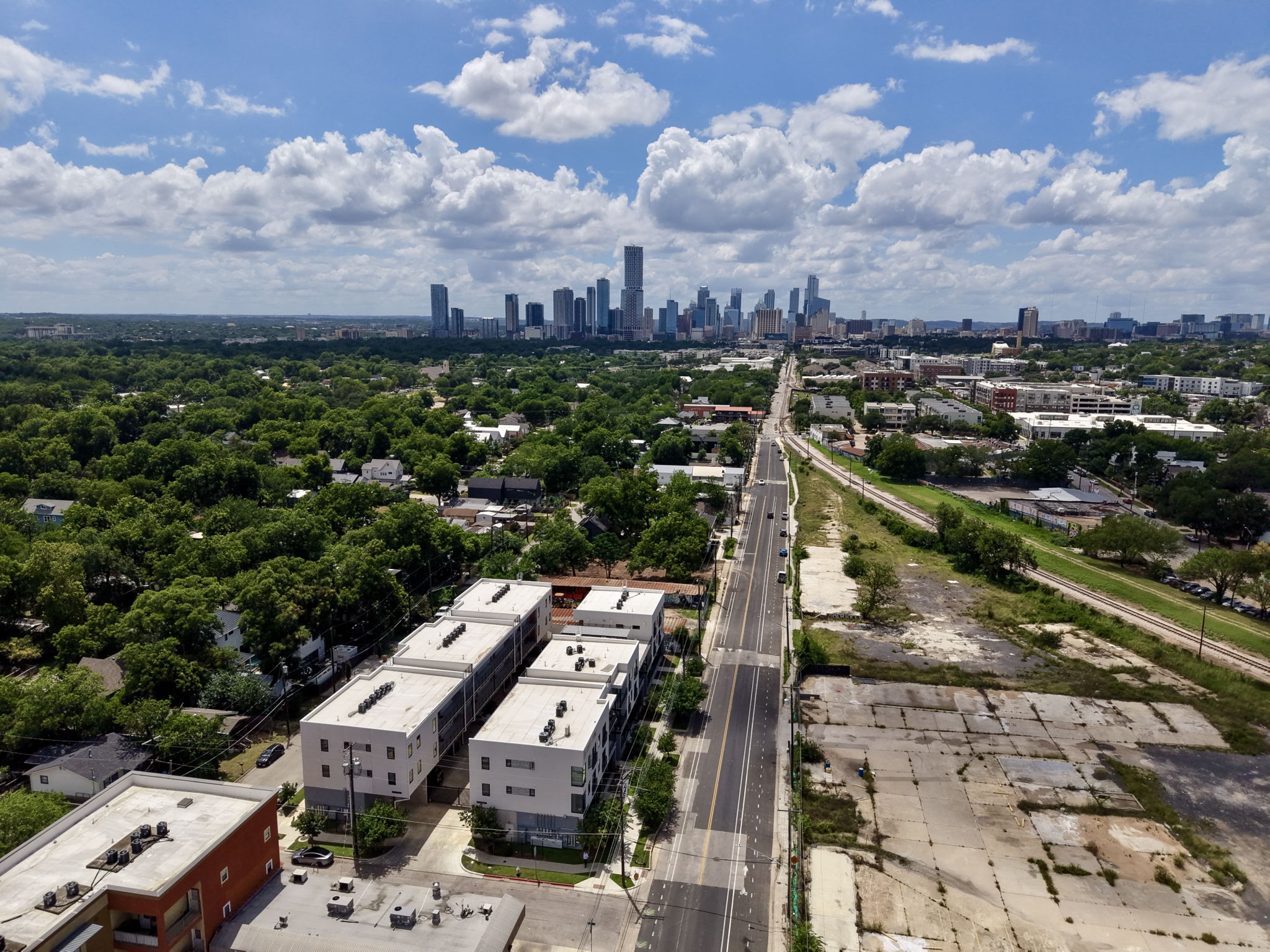 2709 East 5th Street, Unit 1306 Austin, TX 78702 - Photo 20 of 28 An aerial panorama reveals a dynamic city skyline nestled amidst abundant green spaces and urban development.