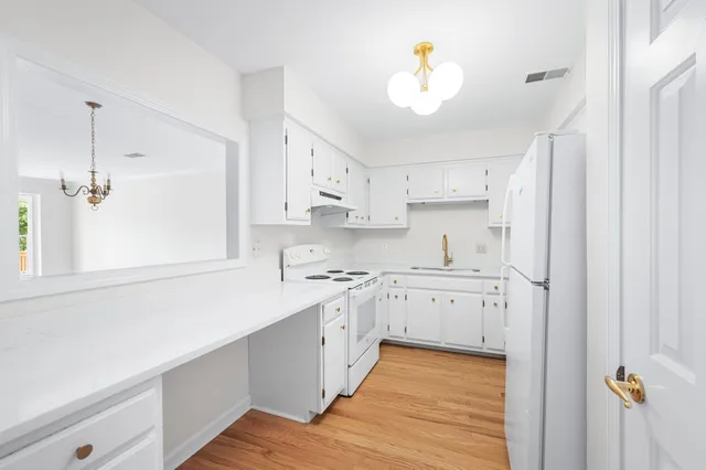 a kitchen with cabinets oven and a sink