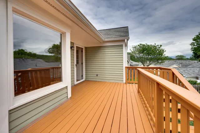 a view of a balcony with wooden floor and fence