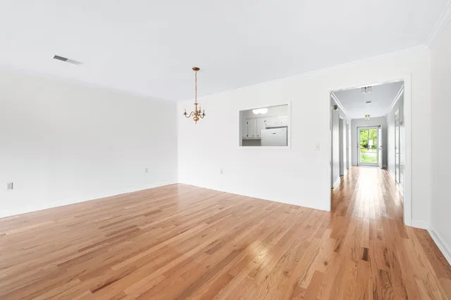 a view of empty room with wooden floor