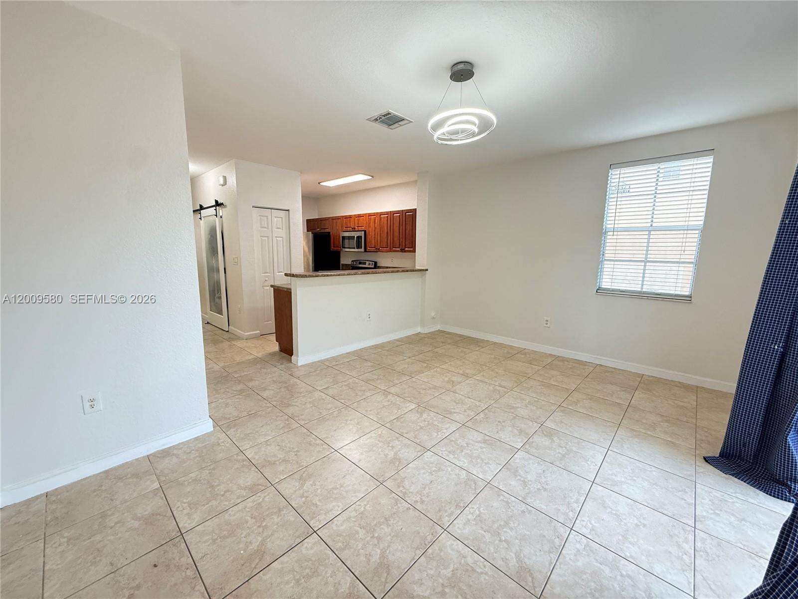 9239 Southwest 227th Street, Unit 1 Cutler Bay, FL 33190 - Photo 18 of 39 a view of a livingroom with an empty space and a window