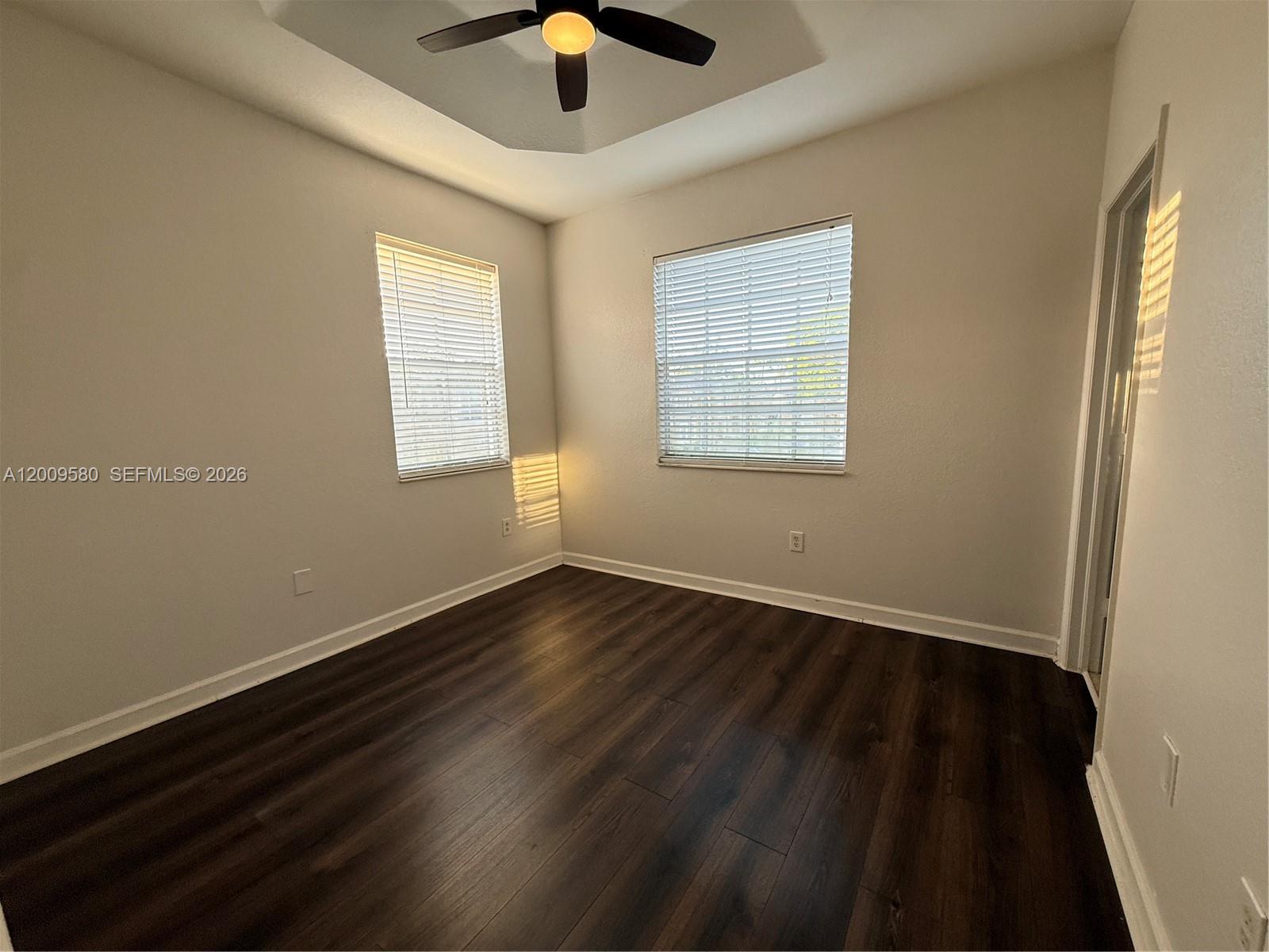 9239 Southwest 227th Street, Unit 1 Cutler Bay, FL 33190 - Photo 20 of 39 an empty room with wooden floor and windows