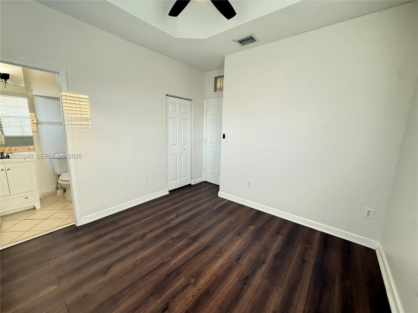 9239 Southwest 227th Street, Unit 1 Cutler Bay, FL 33190 - Photo 21 of 39 a view of an empty room with wooden floor and a window
