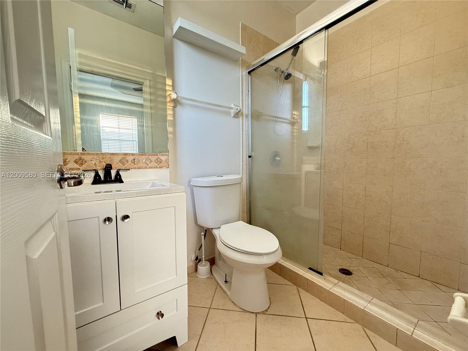 9239 Southwest 227th Street, Unit 1 Cutler Bay, FL 33190 - Photo 23 of 39 a bathroom with a toilet sink and shower