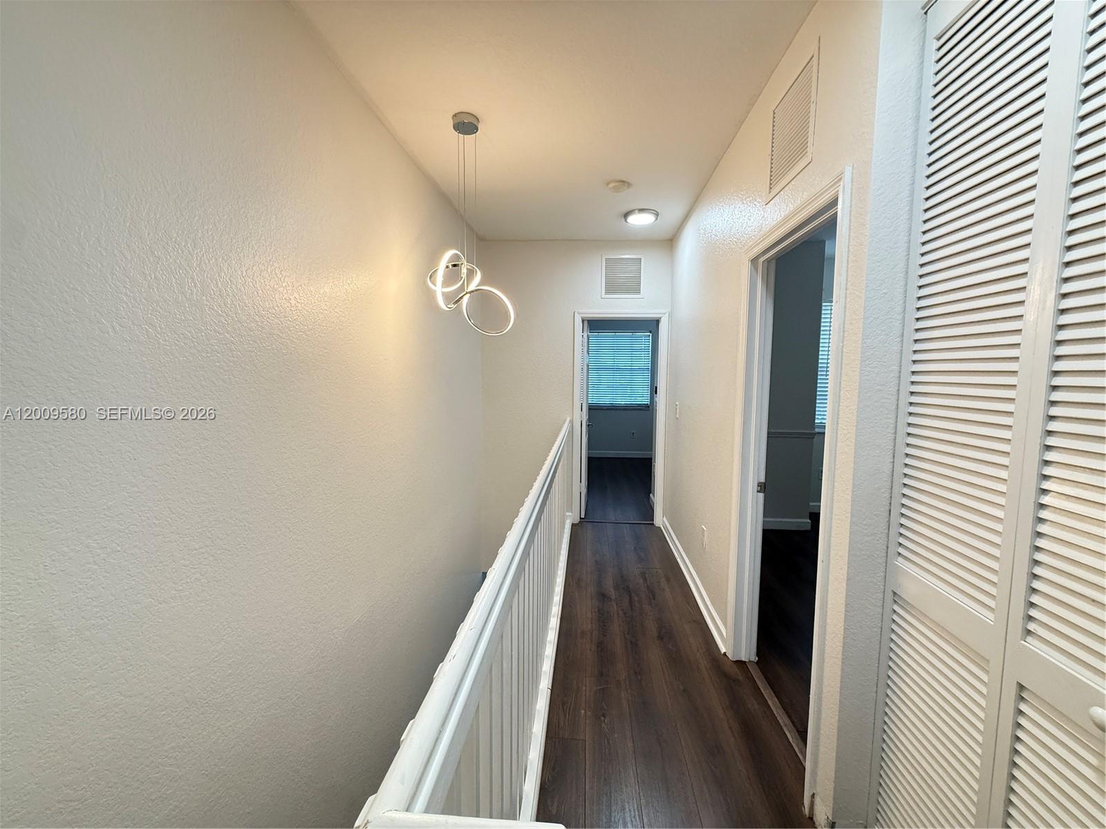 9239 Southwest 227th Street, Unit 1 Cutler Bay, FL 33190 - Photo 24 of 39 a view of a hallway with wooden floor and staircase