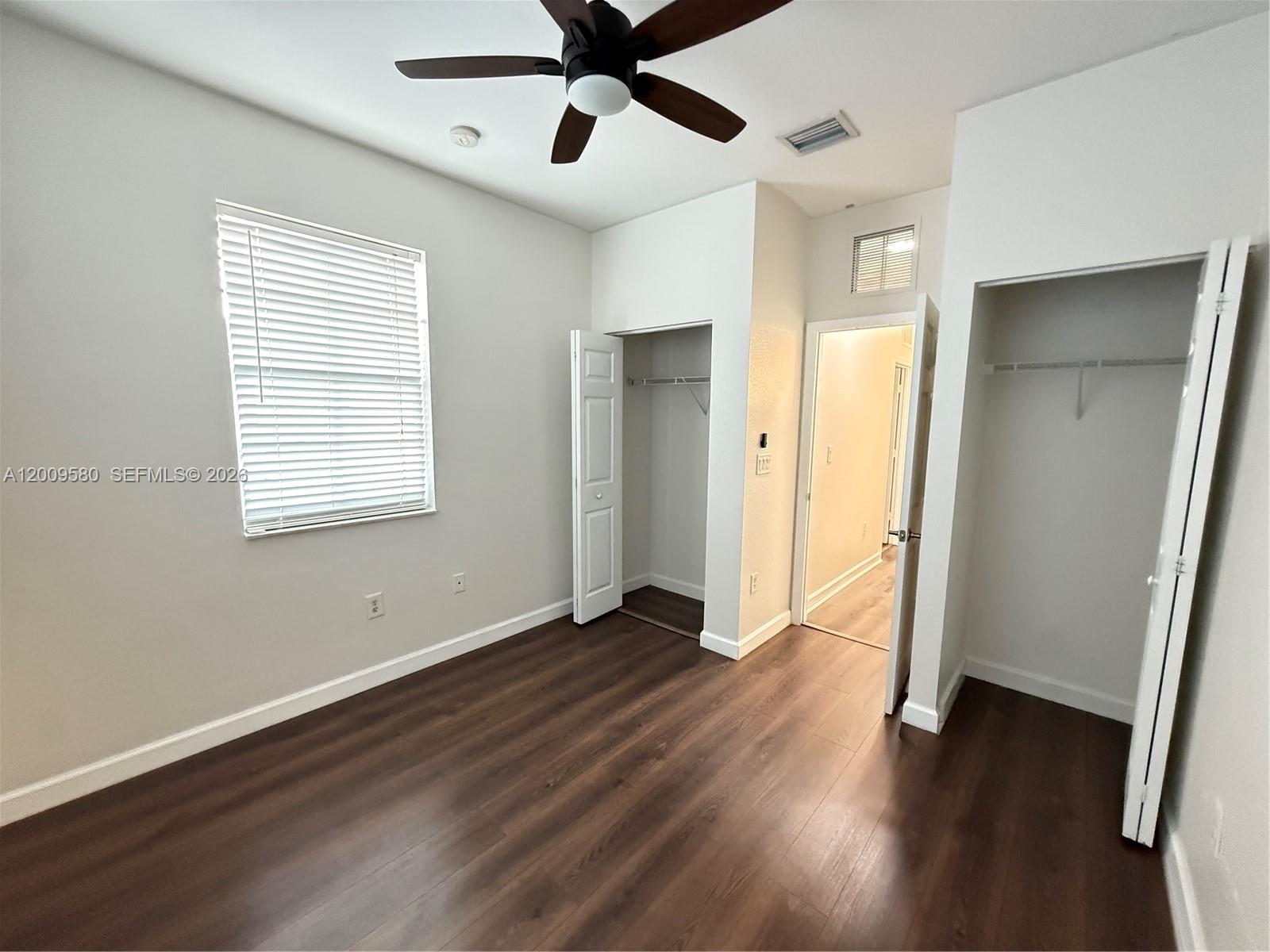 9239 Southwest 227th Street, Unit 1 Cutler Bay, FL 33190 - Photo 26 of 39 a view of an empty room with wooden floor and a window